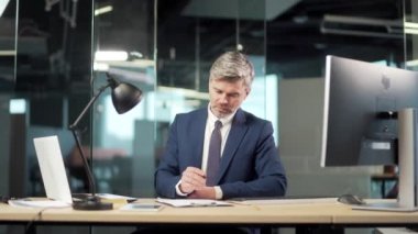 Kıdemli iş adamı ofiste bir onay belgesi imzalıyor. Olgun gri bankacı ya da avukat işadamı. İş ortaklığı sözleşmesi okuyup imzalıyor. Çalışan evrak işi yapıyor