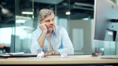 Ofiste ilham kaynağı olmayan olgun bir iş adamı. Sinirli bir işçi. Üzgün ve dağınık kıdemli işadamı iş yerindeki bilgisayar masasında yorgun, yorgun, yaşlı erkek çalışan, tezgahtar 