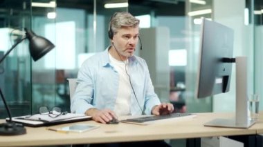 Çevrimiçi konferansta video konuşması yapan yetişkin bir işçi. Kulaklıklı adam, PC Sakal 'da yetişkin danışmanlık hizmetleri ya da modern ofis müşterilerine danışmanlık hizmeti veriyor.