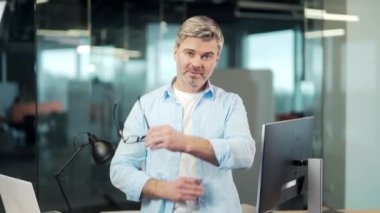 Portre mutlu, yaratıcı ofis çalışanı kameraya bakıyor, gülümsüyor. Gri saçlı yaşlı sakallı iş adamı, iş adamı, gözlüklü serbest çalışan. Mimar, şık tasarımcı kollarını kavuşturmuş.