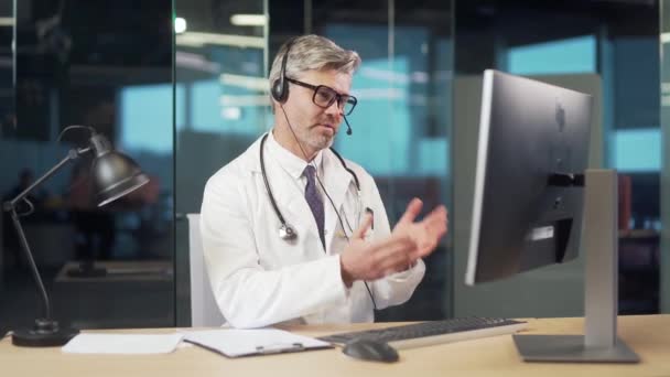老年男性医生在线咨询病人在医院诊所的电话交谈远程处方或药物 有经验的医生男子提供咨询咨询热线 — 图库视频影像