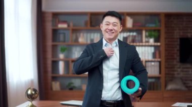 portrait Businessman has finished his working day and is preparing for fitness, Asian is working in a office, late, man is holding a mat for fitness. sports business male looks at the camera