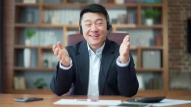 Portrait asian business man employee looking at camera or webcam talking having remote meeting, video conference call, leading corporate training counseling online working in office. Web cam view