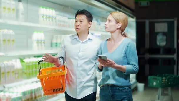 Young Happy Asian Couple Using Smartphone Supermarket Shopping Cart Choosing — Vídeo de Stock