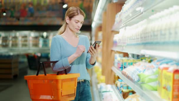 Female Shopper Pick Grocery Store Standing Supermarket Shelves Checking His — Vídeo de Stock