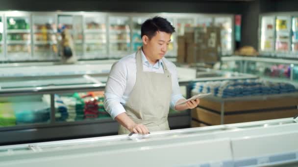 Asian Grocery Store Manager Salesman Apron Using Digital Tablet Counting — Stockvideo