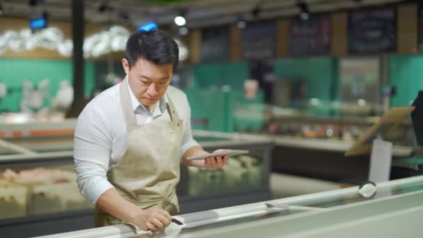 Asian Grocery Store Manager Salesman Apron Using Digital Tablet Counting — 图库视频影像