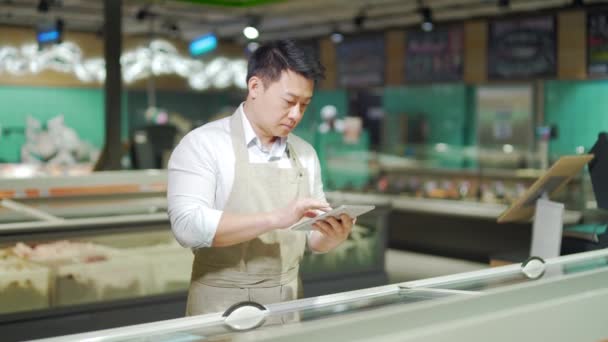 Asian Grocery Store Manager Salesman Apron Using Digital Tablet Counting — 비디오