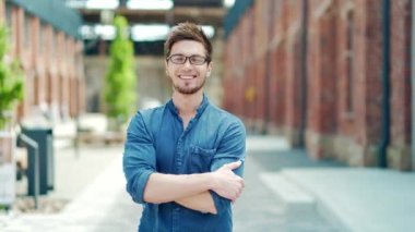 portrait handsome young male student in casual denim shirt and glasses looking at camera on urban university campus background. outside. Happy glad stylish caucasian guy. cheerful smiling, laughing