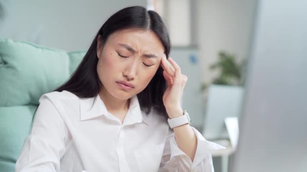 Exhausted Overworked Asian Office Worker Sitting Workplace Severe Headache Massaging — Vídeo de Stock