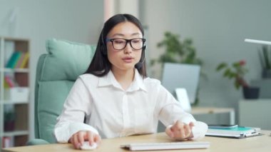 Corporate operator working in customer support service on helpline telesales asia woman representative call center agent in wireless headset helping client complaints looks at camera. webcam view