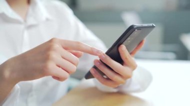 Kapalı bir iş kadını ev telefonunda cep telefonuyla mesaj yazıyor, genç bir kız akıllı telefonda sohbet ediyor. Öğrenci kadın ellerini bilgisayar masasında kullanarak, gezinerek, sohbet ederek, mesajlaşarak kapat 