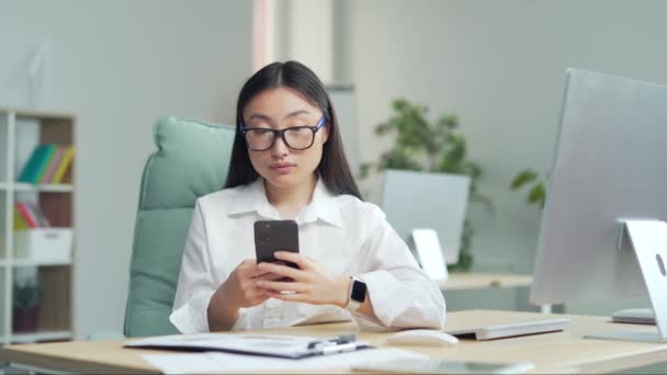 Happy Asian Business Woman Employee Entrepreneur Uses Smartphone Sitting Workplace — Stockvideo