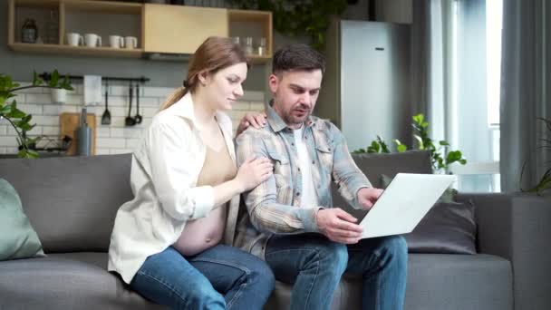 Happy Family Husband Hugs Pregnant Wife Sit Together Sofa Enjoy — Stockvideo