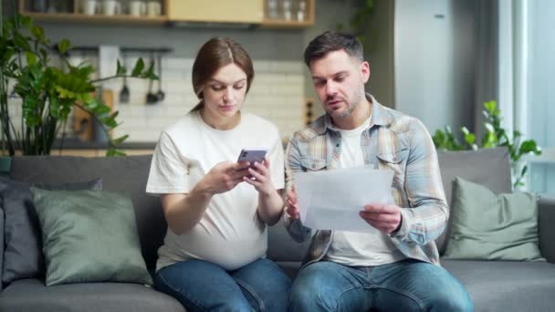 Young Married Couple Husband Pregnant Wife Together Home Sitting Sofa — Αρχείο Βίντεο