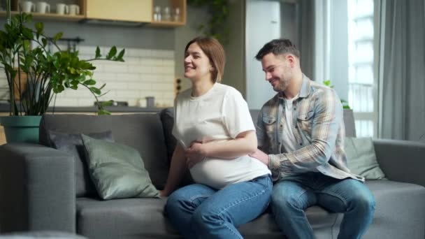 Husband Gives Pregnant Wife Back Massage Pregnancy Sitting Sofa Home — Stockvideo