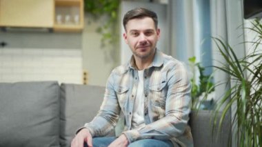young man in casual clothes talking online on video call, remote meeting or conference, learning webcam view. Portrait of male at home conversation looking at camera waving his hand. indoor