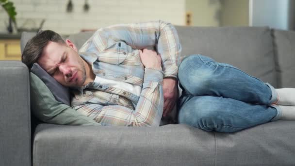 Young Handsome Man Lying Sofa Home Severe Abdominal Pain Stomach — Vídeos de Stock