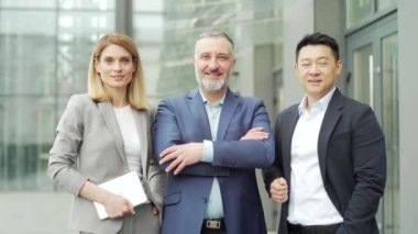portrait of multiracial happy professional team of business people, businessmen employees in formal suits looking at camera. Group office workers outside Asian man, Caucasian woman and mature male