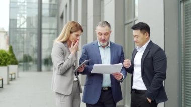 dissatisfied with the results, boss or director quarrels, scolds employees looking at report document Angry manager with bad work financial performance standing with workers outside office building