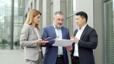 dissatisfied with the results, boss or director quarrels, scolds employees looking at report document Angry manager with bad work financial performance standing with workers outside office building