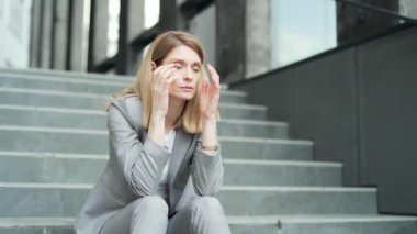 sad business woman employee with depression office worker in formal suit sitting on stairs on city street near office building. outside. jobless businesswoman fired Lay off. Dissmissal company manager