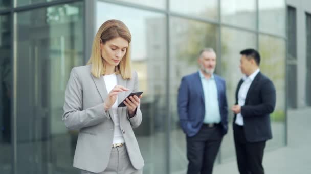 Business Woman Formal Suit Uses Smartphone Background Colleagues Workers Office — Stockvideo