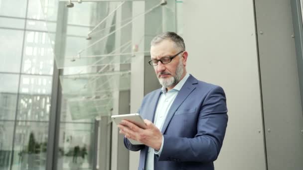 Serious Thoughtful Business Man Uses Smartphone While Standing Office Building — 비디오