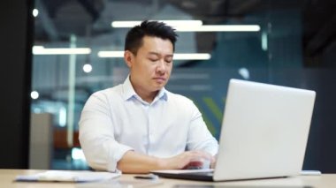 Asyalı bir ofis çalışanı işyerinde otururken hiç hareket göstermiyor. Kameraya bakıyorum. Parmak izi yok, anlaşmazlık sembolü yok. Konuşmayı durdur, jest yap, webcam görüntüsü var.