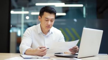 Asyalı çalışanın ofisteki projeden kötü sonuç almasına sinirlenmiş iş adamının hata bulması belgelerde başarısız olması işyerindeki kötü mali performans