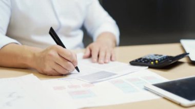 Mali analistin ya da muhasebecinin hesap makinesiyle ilgili döküman ve grafikleri sayma raporunu kapat. Meşgul. Bilgisayar masasında çalışan bir çalışan. İşletme müdürü ofiste. Yakın çekim.