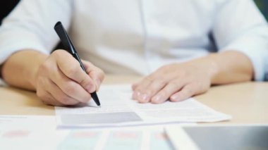 Kapanışta, İşadamı kalemle masada bir yatırım sözleşmesi imzalıyor. Çalışan bir ifade yazar, masa başında sorgulama bildirimi. Kapat.