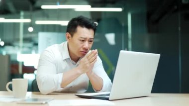 Ofisteki bilgisayar ekranına bakan iş adamı sonuçlarından memnun değil. Kızgın olgun Asyalı iş adamı çalışan avukat analist yönetici kötü çalışma ve internet başarısızlığı