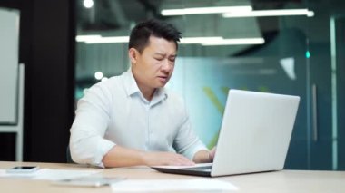 Kalp krizi geçiren Asyalı bir iş adamı. Kalp ağrısı olan bir ofis çalışanı. Sandığı tut. Erkek işadamı bilgisayar masasında oturuyor. Müdür işyerinde acı çekiyor. Kapalı alanda. Asya