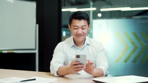 Feliz Trabajador Oficina Asiático Sentado Escritorio Computadora Oficina Usando Teléfono — Vídeos de Stock