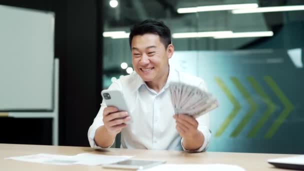 Sikeres Ázsiai Üzletember Kezében Telefon Pénz Dollár Készpénz Győzelem Nyert — Stock videók