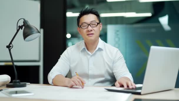 Retrato Hombre Asiático Ingeniero Arquitecto Diseño Mirando Cámara Sentado Lugar — Vídeo de stock