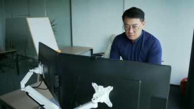 Konsantre Asyalı programcı, mali analist ya da ofisindeki bilgisayar masasında çalışan tüccar. Ofisteki uzman çalışanlar, monitördeki problemleri çözmeyi düşünüyor.