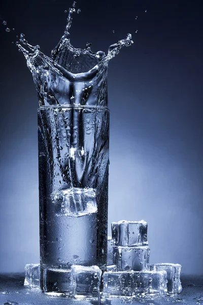 Spruzzi d'acqua in un bicchiere Foto Stock