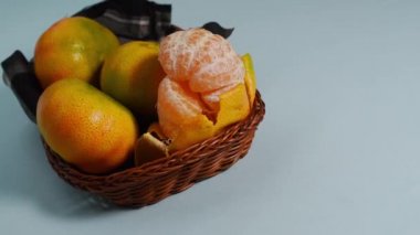 Fotokopi alanı olan mavi bir yüzeyde sepette taze mandalinalar. 