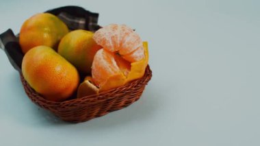 Fotokopi alanı olan mavi bir yüzeyde sepette taze mandalinalar. 