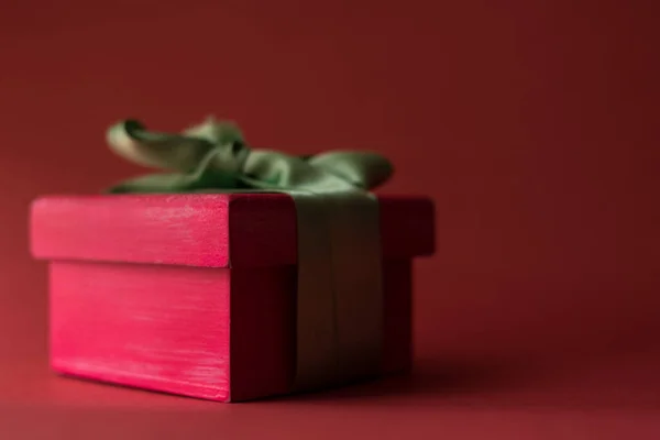 Caixa Presente Rosa Com Uma Fita Verde Uma Superfície Vermelha — Fotografia de Stock