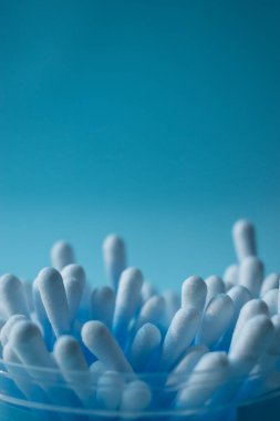 Mavi arka planı olan mavi pamuklu çubuklar. 