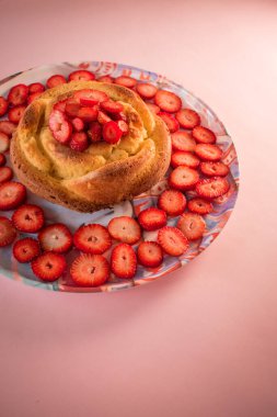 Pembe arka planda çilek dilimleri olan kek.