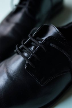 Yeşil bir yüzey üzerinde parlak siyah ayakkabılar. 