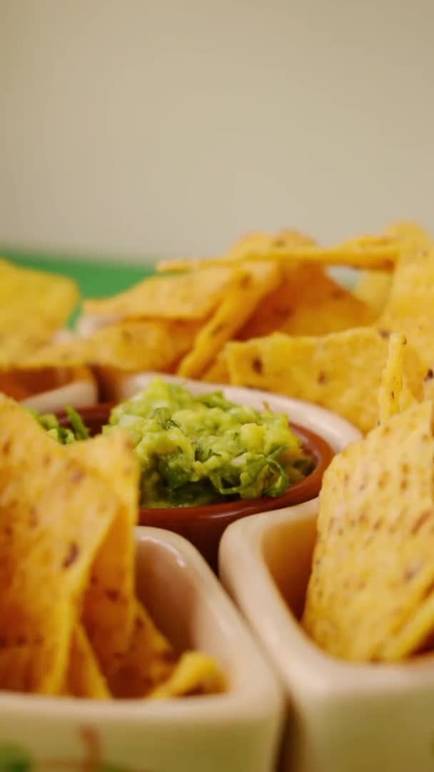 Vídeo Vertical Mano Tomando Nacho Frito Una Olla Con Guacamole — Vídeo de stock