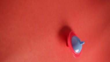 Kırmızı bir yüzey üzerinde dönen mavi ve kırmızının sözlü videosu 