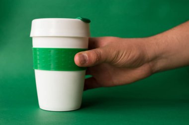 Yeşil arka planda sıcak içecekler için plastik termos