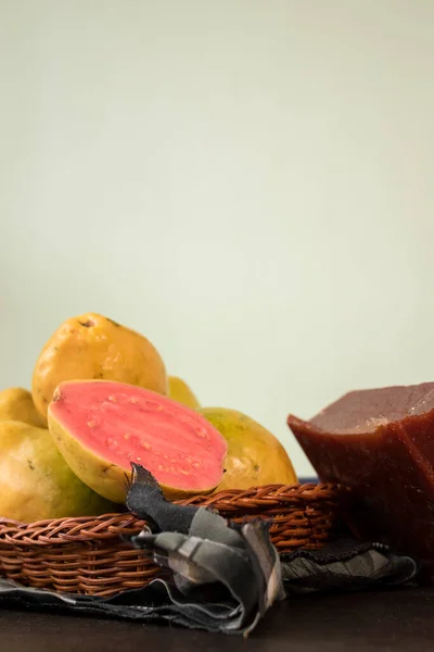 Kolombiya 'nın guava adındaki tropikal meyvesi ve siyah ahşap masada sepet içinde Bocadillo denilen Kolombiya şekeri. 