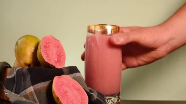 哥伦比亚的热带水果叫做番石榴 它的汁液由一只手放在黑色木制桌子上的一个木箱里制成 — 图库视频影像